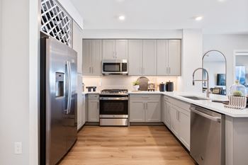a kitchen with stainless steel appliances and white cabinets at Stonehill at West Orange, West Orange